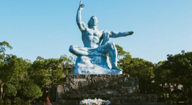 Statua della Pace a Nagasaki con visitatore davanti al monumento, esempio tra le famose statue che simboleggiano la pace nel mondo.